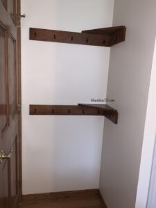 Behind the door shelving with hooks for extra storage