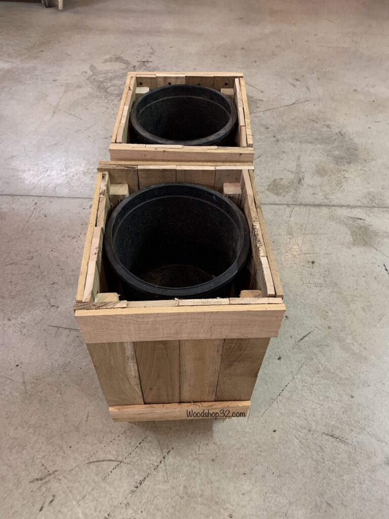 pallet wood planter with black plastic nursery container