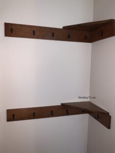 Behind the door shelving with hooks for extra storage