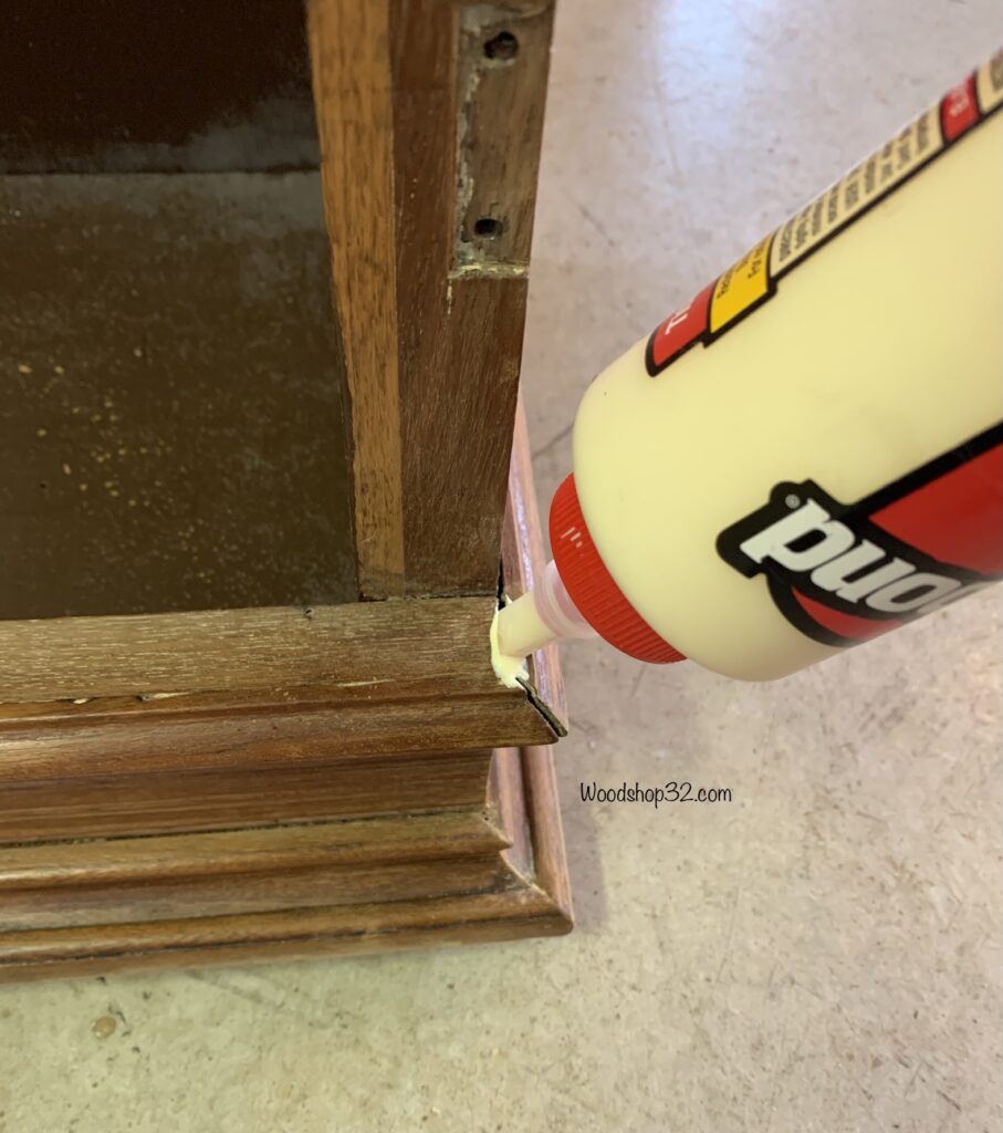 applying wood glue to cabinet